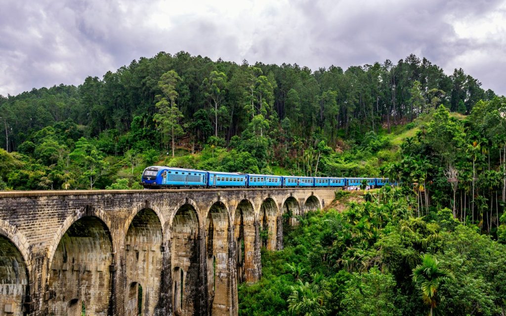 Blue train crossing the Nine Arches Bridge in Ella Sri Lanka