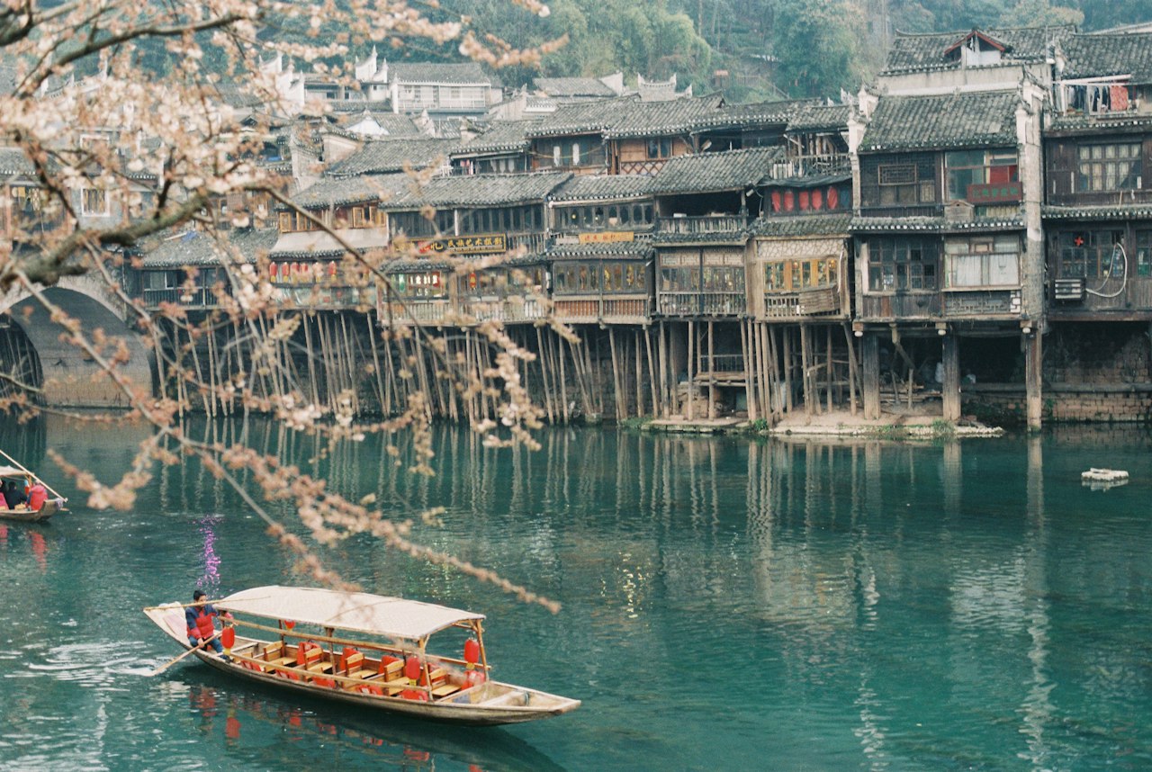 Wooden boat on the river near old buildings