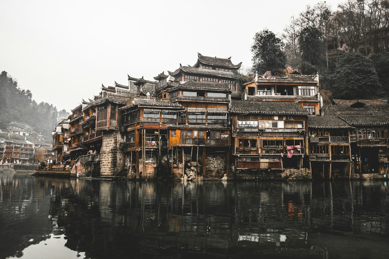 Brown wooden houses beside a calm river
