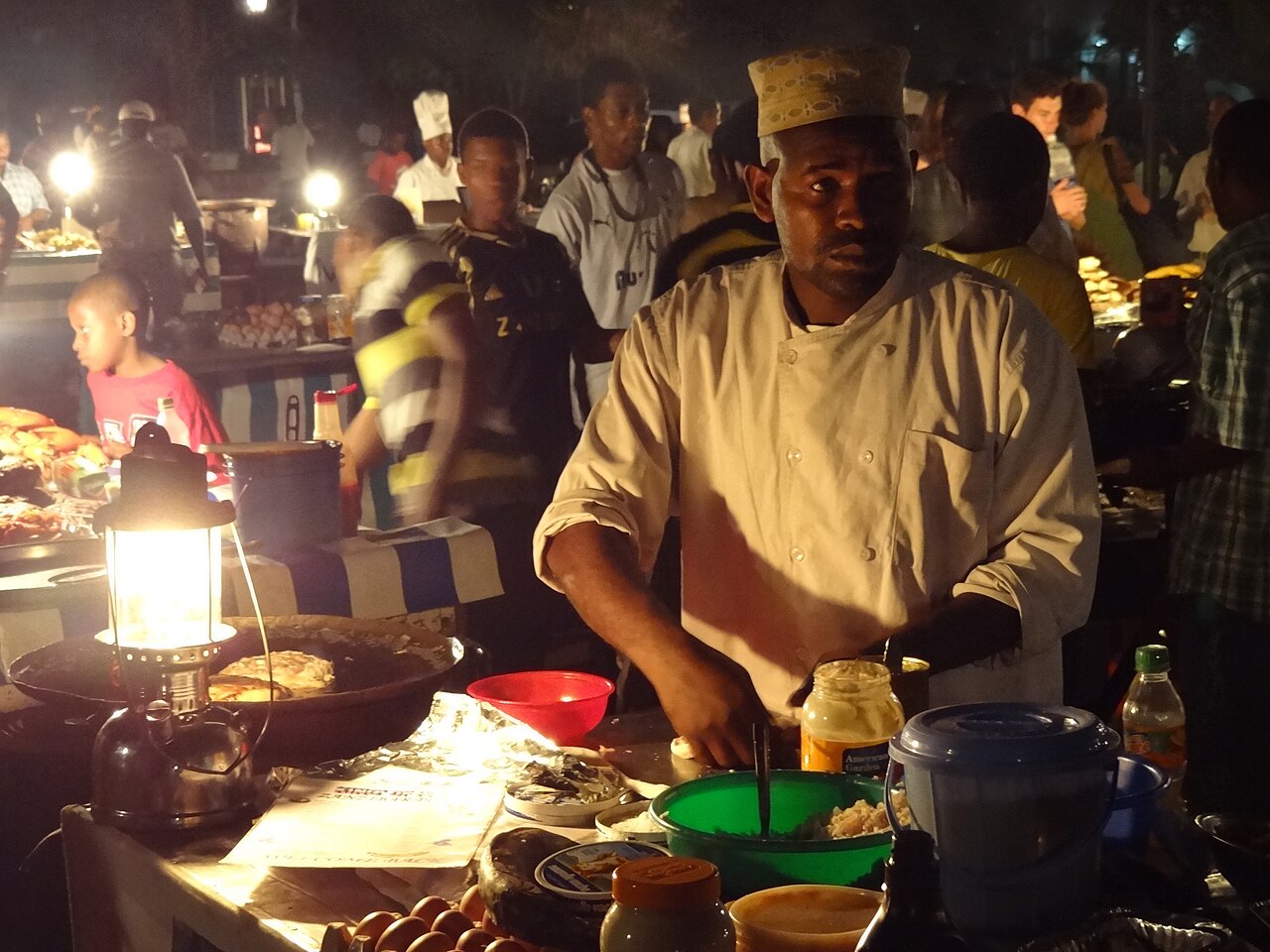 Food vendor grilling seafood at Forodhani Gardens night market