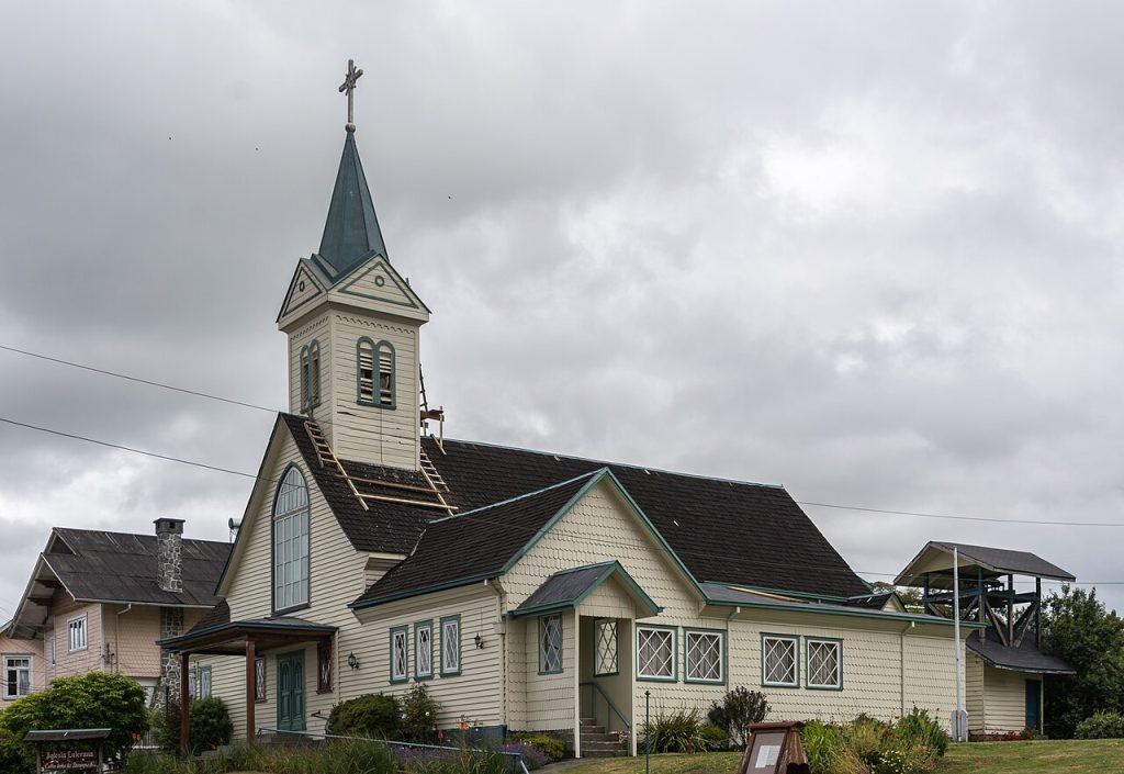 White wooden church with a pointed steeple in Frutillar