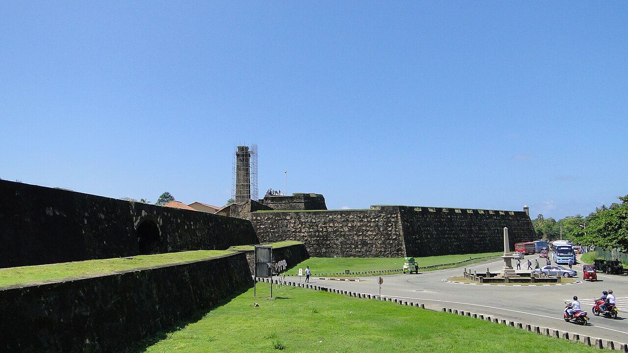 People walking along the Galle Fort ramparts at sunset