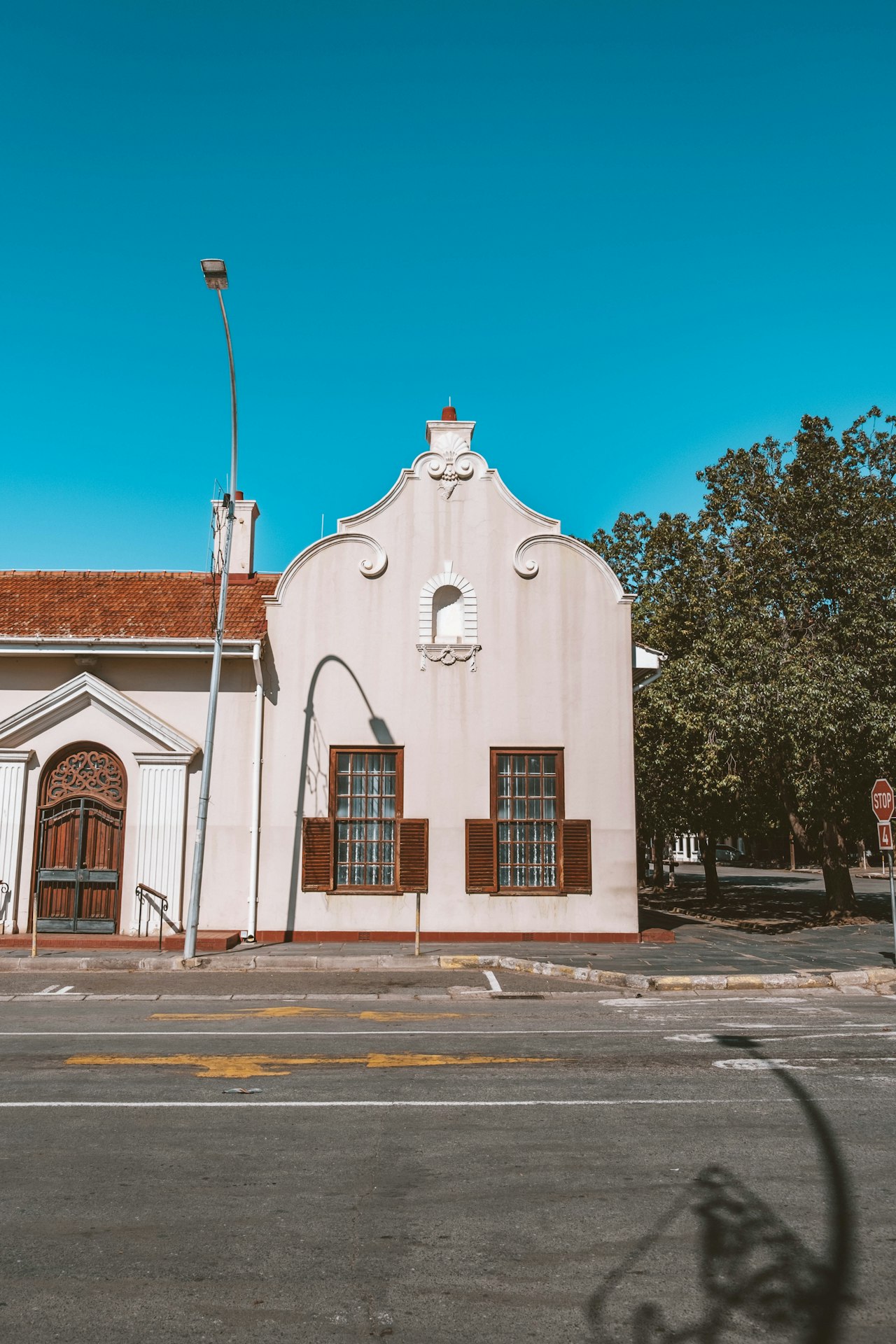 White heritage building beside a quiet road