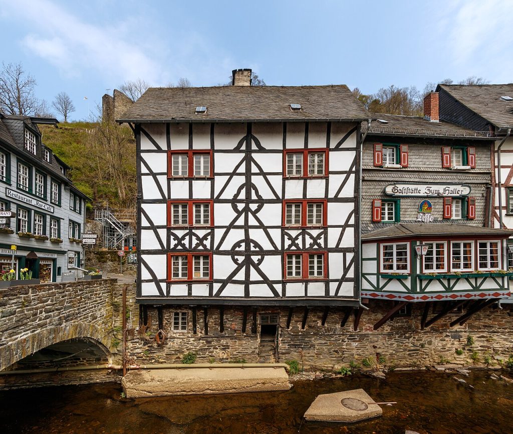 A black and white half-timbered house with red shutters