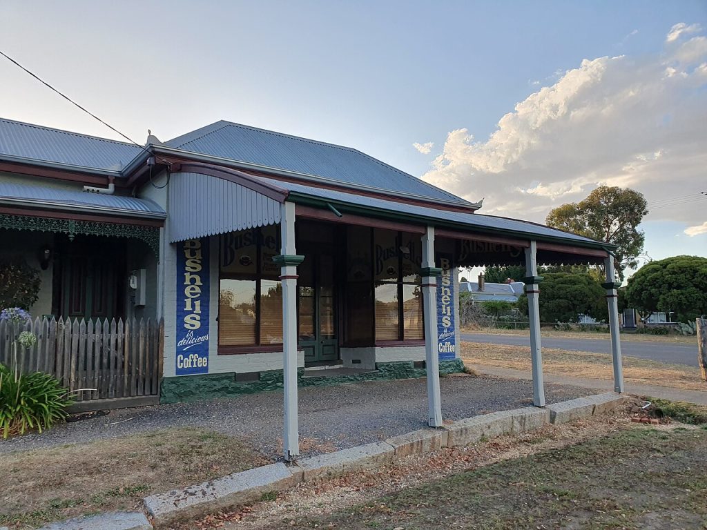 A historic shopfront with a timber verandah and painted signs