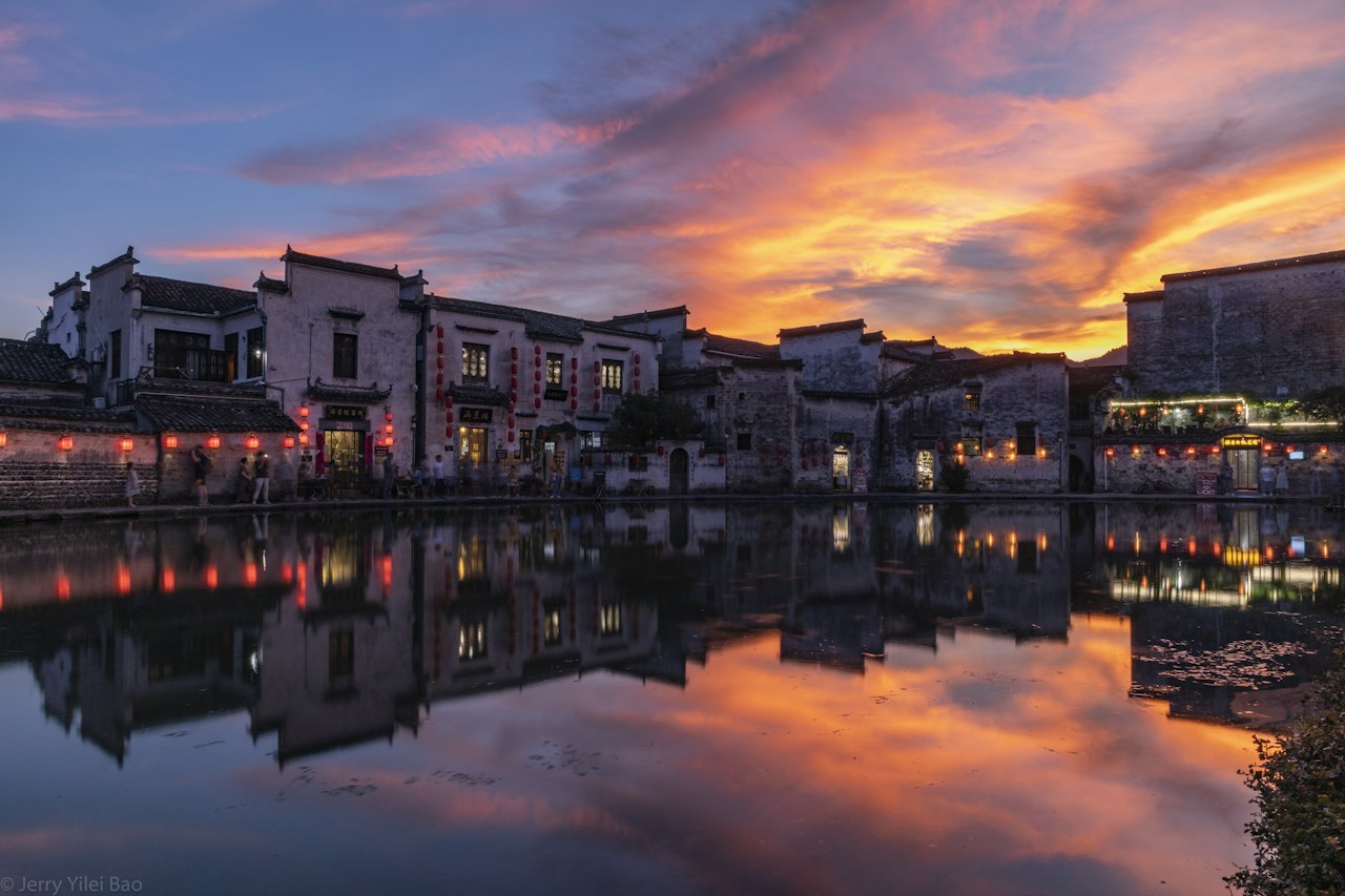 Village buildings beside the water at sunset