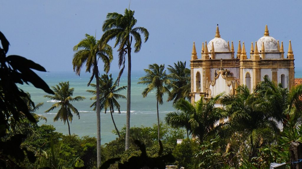 Baroque Carmo church framed by palm trees and the ocean