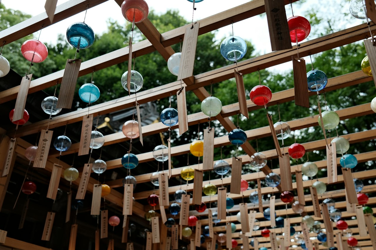 Glass wind chimes hanging from a wooden frame