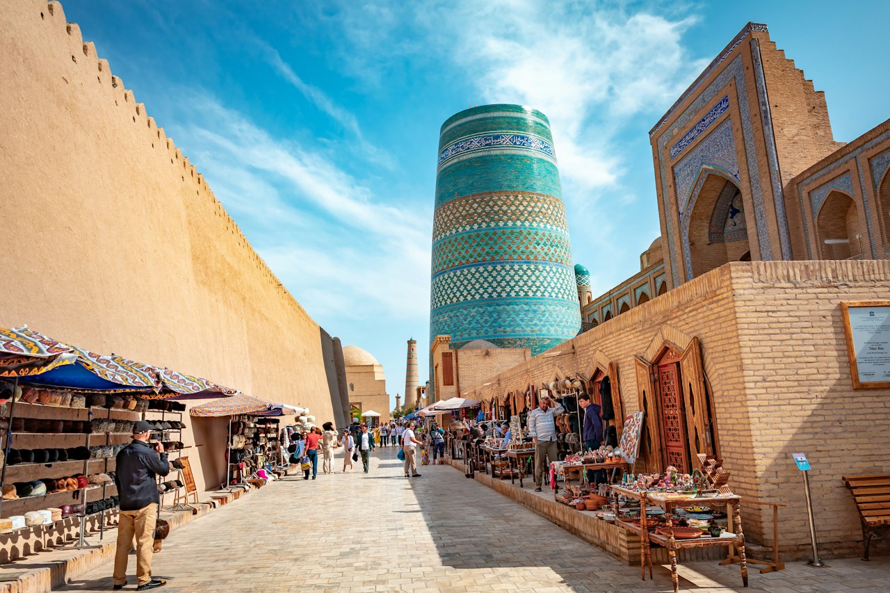 Narrow lane leading toward a tall tiled tower