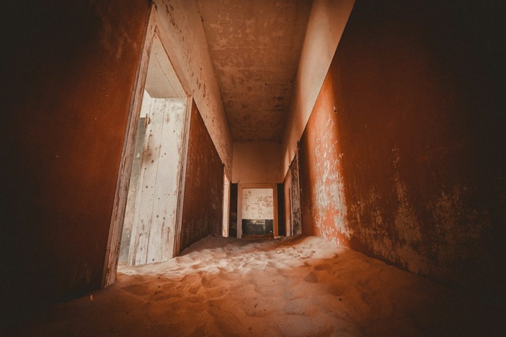 A hallway filled with desert sand in an abandoned house