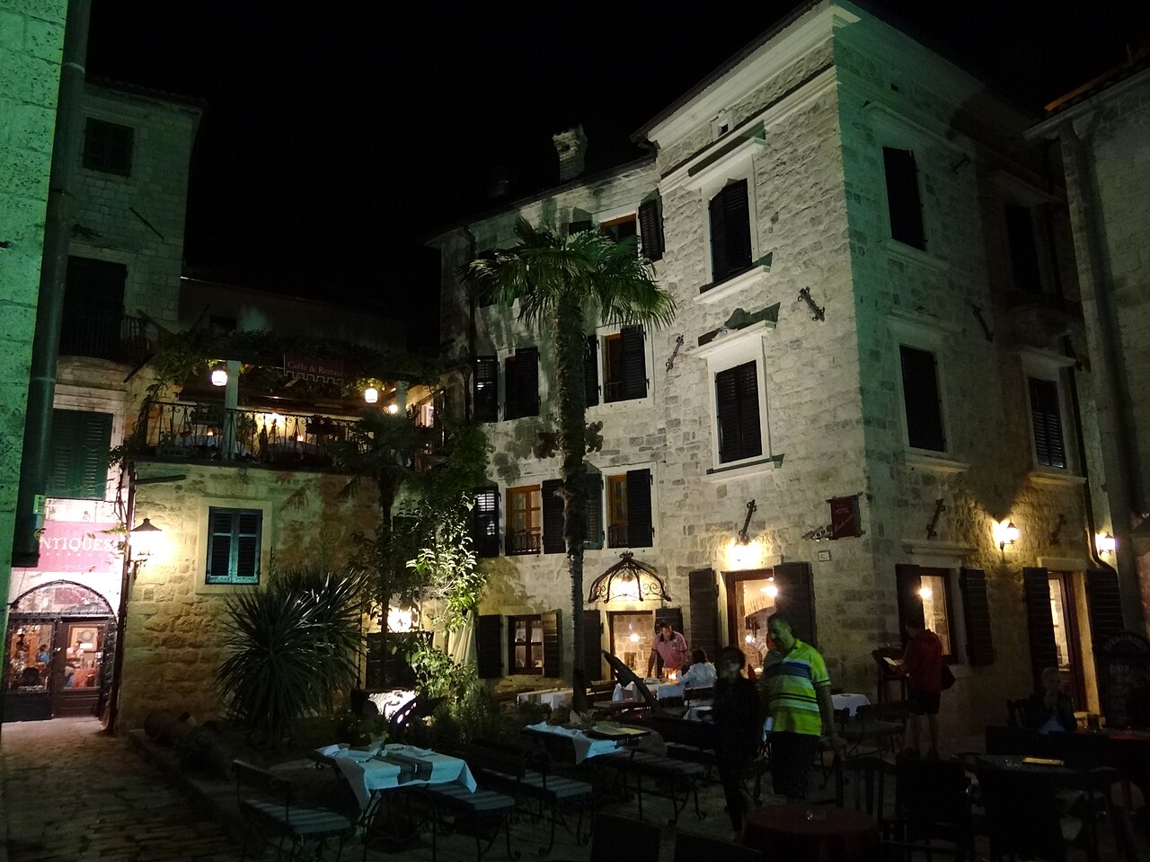 Outdoor cafes lit up at night in Kotor old town