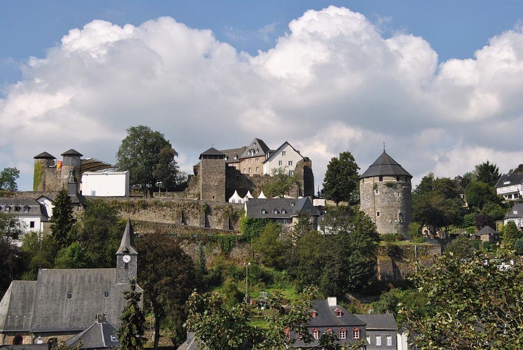 Monschau castle on a wooded hill above the town