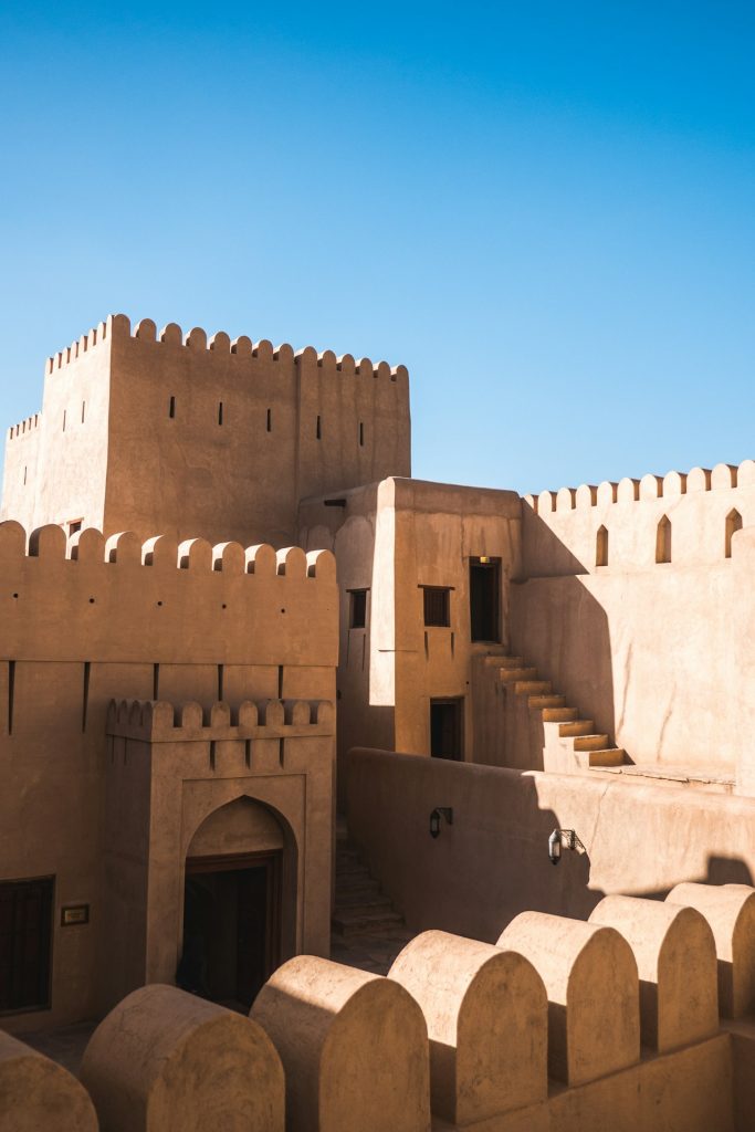 Sand colored battlements and towers under a blue sky
