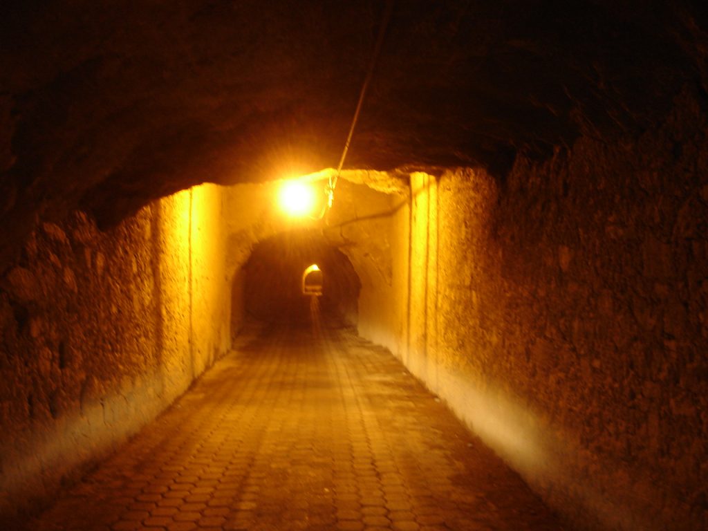 Inside the long stone Ogarrio Tunnel lit by lamps