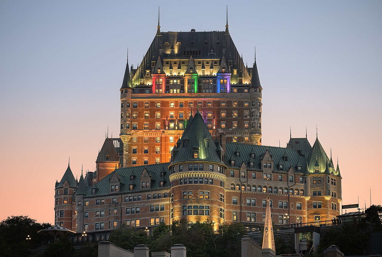 Château Frontenac hotel glowing at dusk above Old Quebec City