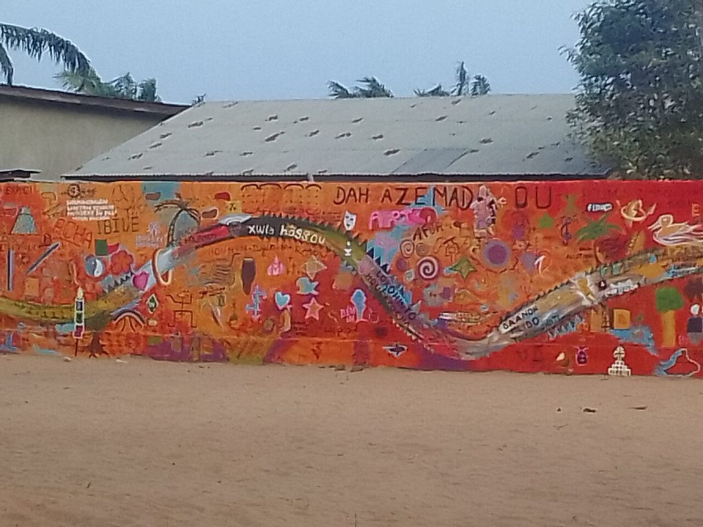 A long colorful mural painted on a town wall