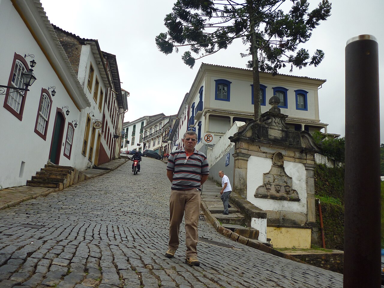 Steep cobblestone street lined with colorful colonial houses