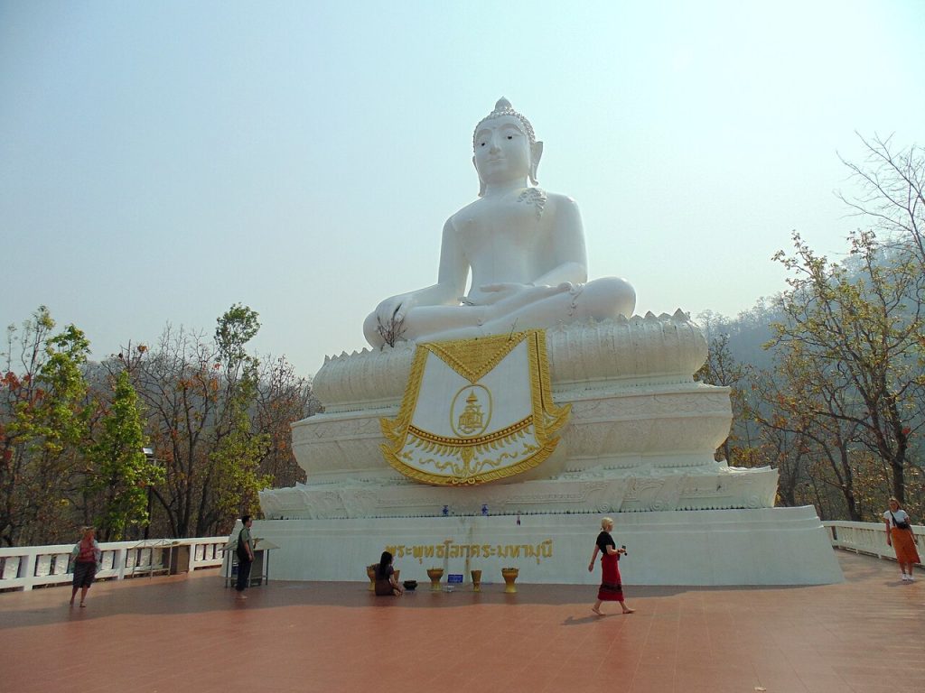 White Buddha statue on a hill above town