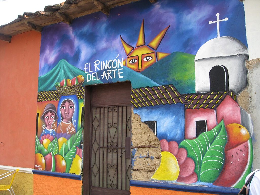 A colorful mural painted on a shop wall reading El Rincón del Arte