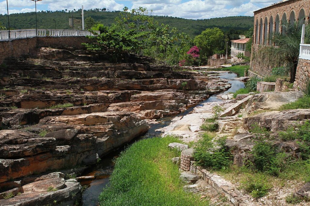 A stream flowing over smooth rock terraces near town