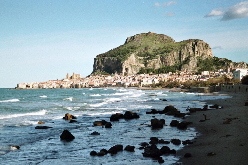 A coastal town and rocky headland seen across the bay