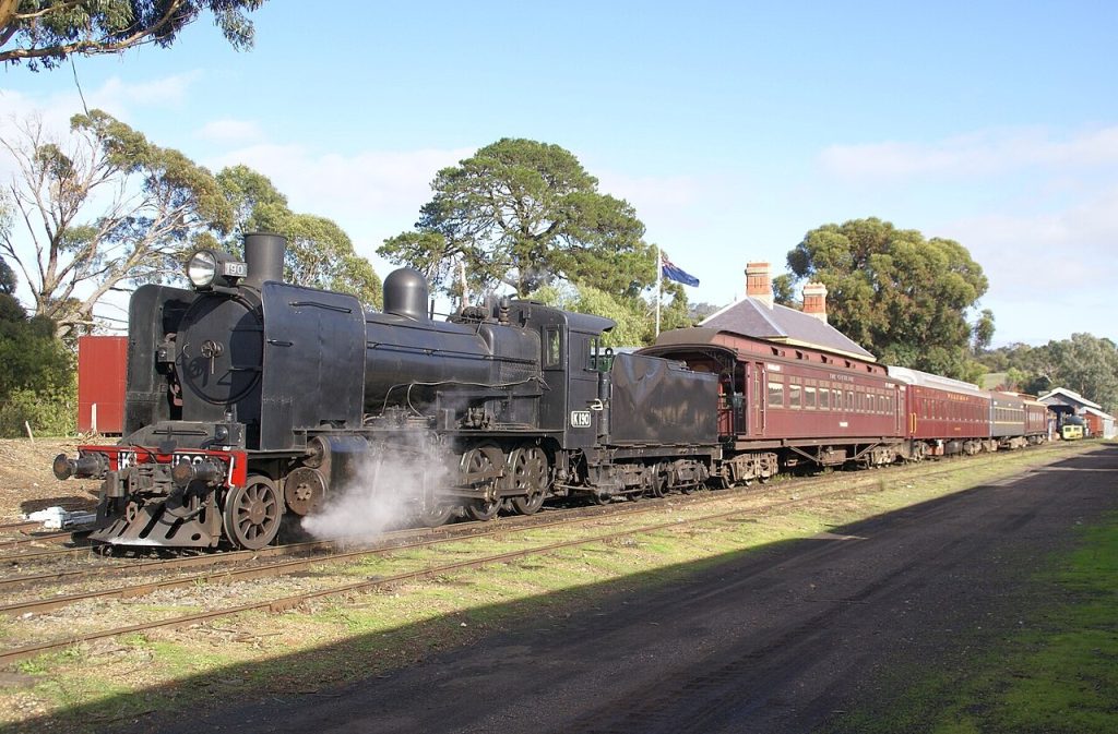 A black steam locomotive pulling heritage carriages