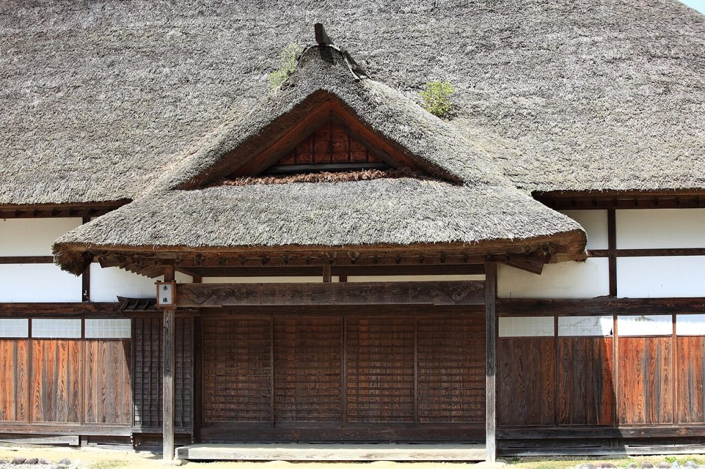 Close view of a traditional thatched roof and wooden facade