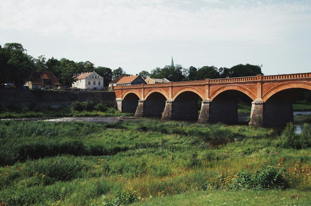 The long arched brick bridge across a green river valley